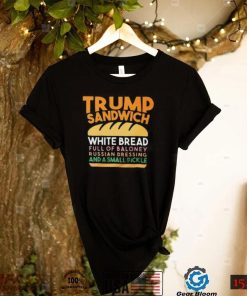 Trunp sandwich white bread full of bakone y russian dressing and a small picke shirt